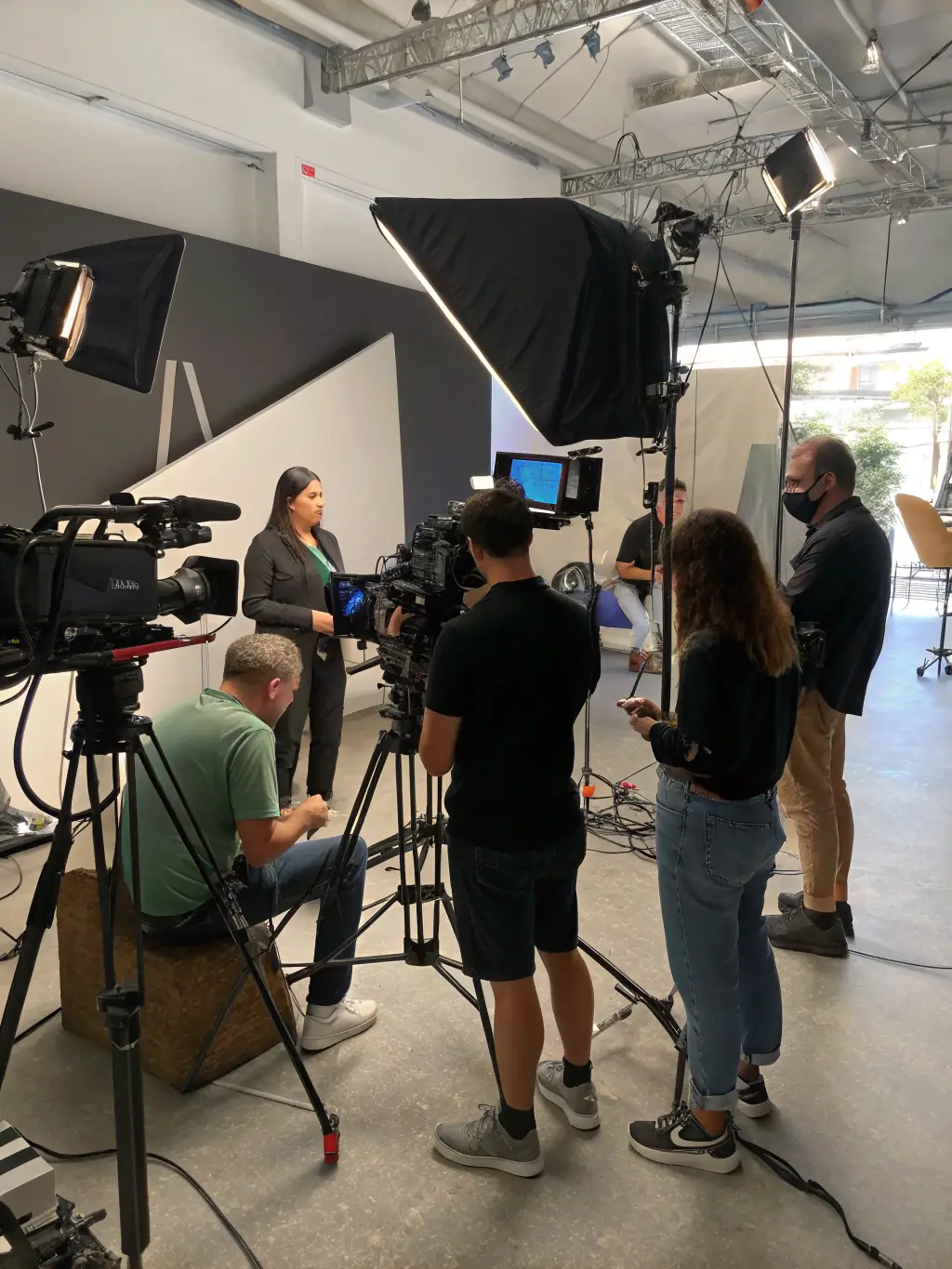 Participants collaborating on a video project, filming a scene with professional equipment and guidance, set in a creative studio space.
